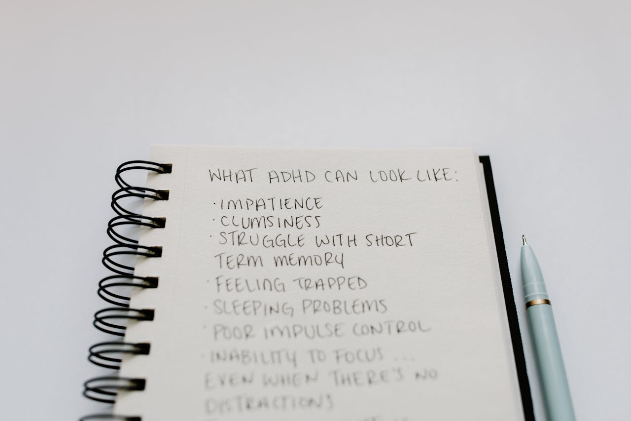Services A notebook with handwritten ADHD symptoms like impatience and focus issues.
